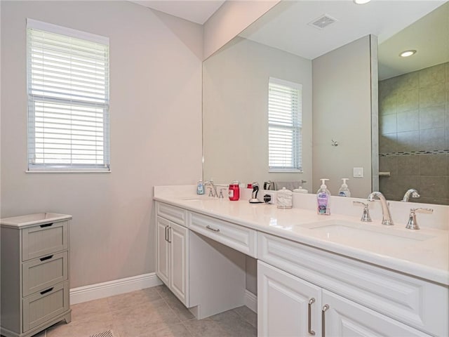 bathroom with tile patterned floors, vanity, and a healthy amount of sunlight