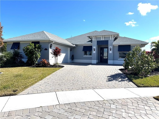 view of front of home with a front yard and a garage