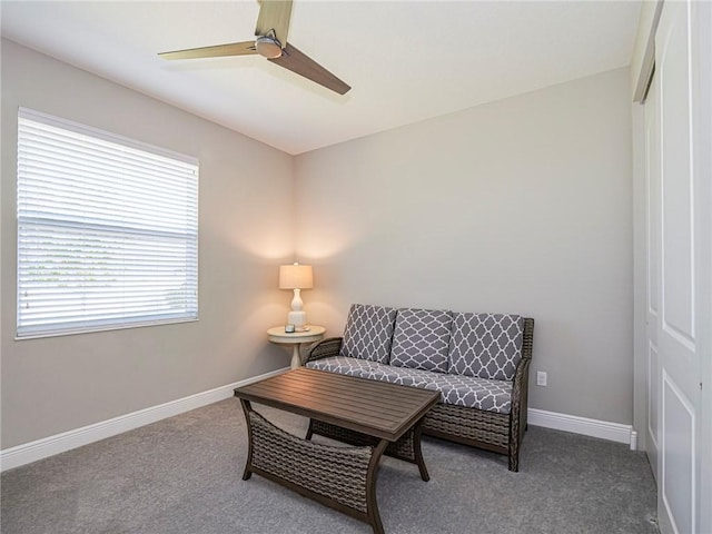 living area featuring carpet flooring and ceiling fan