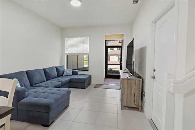 living area featuring light tile patterned flooring, visible vents, and baseboards