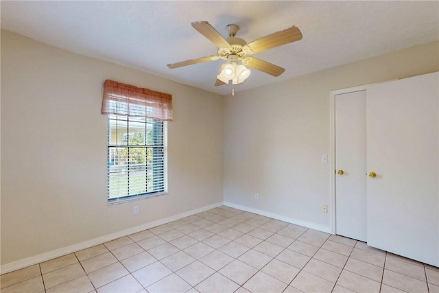 unfurnished room featuring light tile patterned floors, baseboards, and a ceiling fan