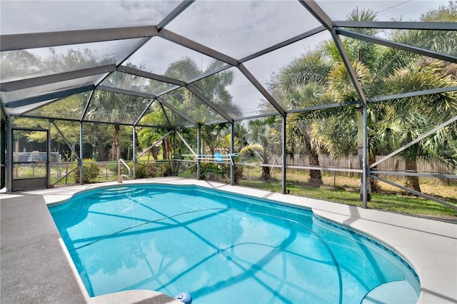 view of pool with a lanai and fence