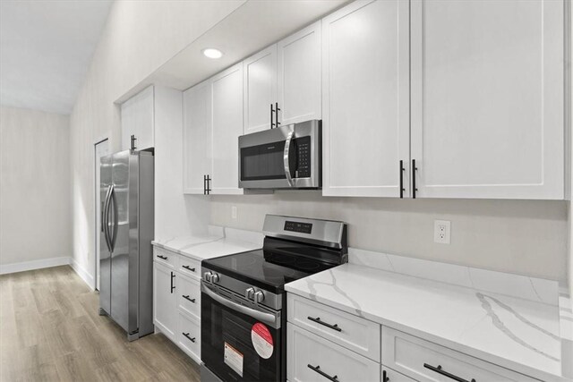 kitchen featuring white cabinetry, dark wood-type flooring, an island with sink, decorative light fixtures, and appliances with stainless steel finishes