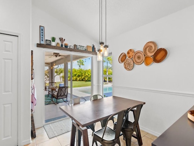 dining space with baseboards, ceiling fan, light tile patterned flooring, and vaulted ceiling