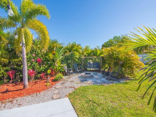 view of grassy yard featuring an outdoor fire pit and a patio