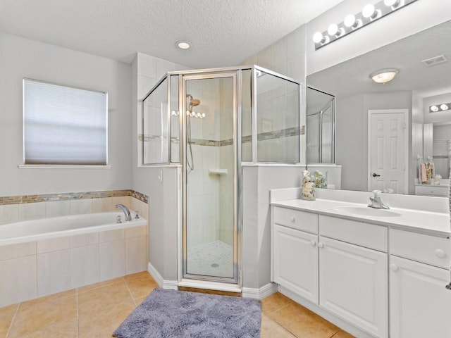 920 Southlakes Way SW, Vero Beach, FL 32968 - bathroom with vanity, tile patterned floors, a shower stall, a garden tub, and a textured ceiling