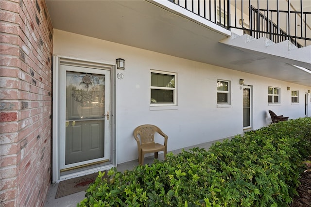 view of exterior entry with a balcony