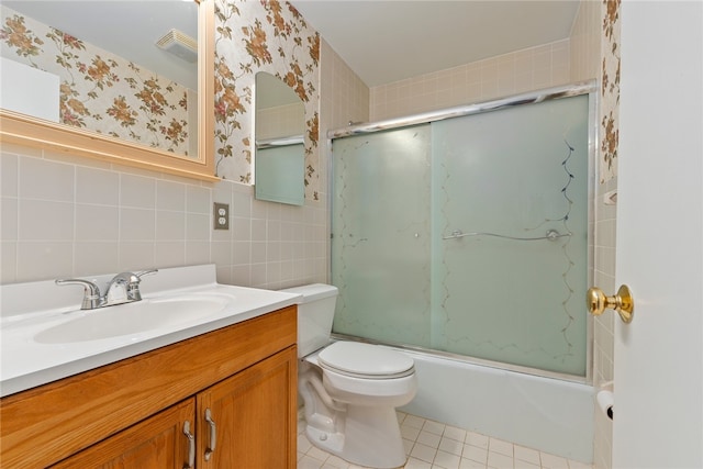 full bathroom featuring tile walls, tile patterned floors, vanity, toilet, and combined bath / shower with glass door