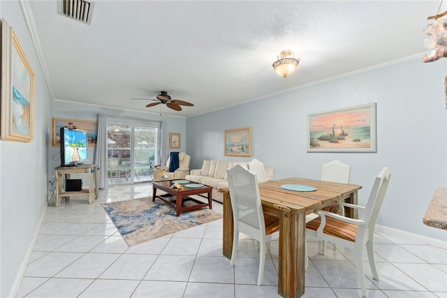 tiled dining area featuring ceiling fan, a textured ceiling, and ornamental molding