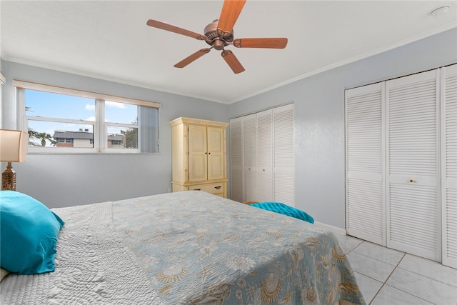 tiled bedroom featuring multiple closets, ceiling fan, and crown molding