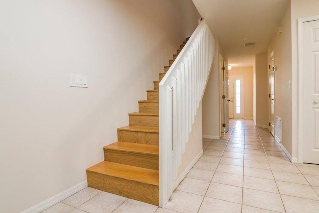 staircase featuring tile patterned flooring, visible vents, and baseboards