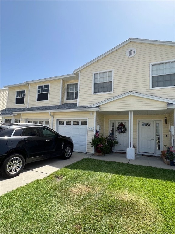 view of property featuring a garage, concrete driveway, and a front lawn