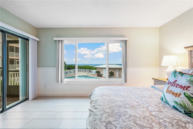 bedroom featuring a textured ceiling and access to outside