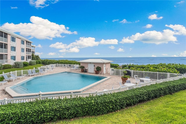 view of pool with a patio and a water view