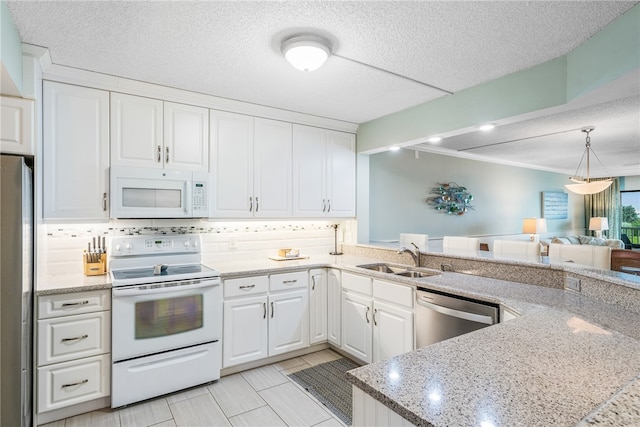 kitchen featuring white cabinetry, sink, light stone counters, appliances with stainless steel finishes, and a textured ceiling