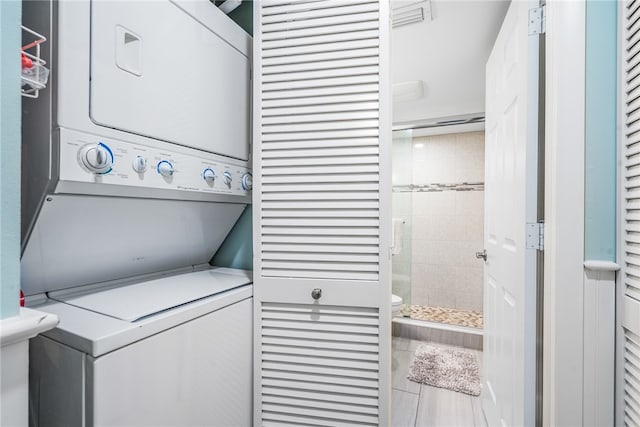 laundry area featuring tile patterned flooring and stacked washer / dryer