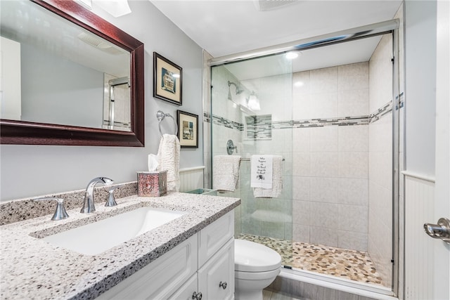 bathroom with walk in shower, vanity, and toilet