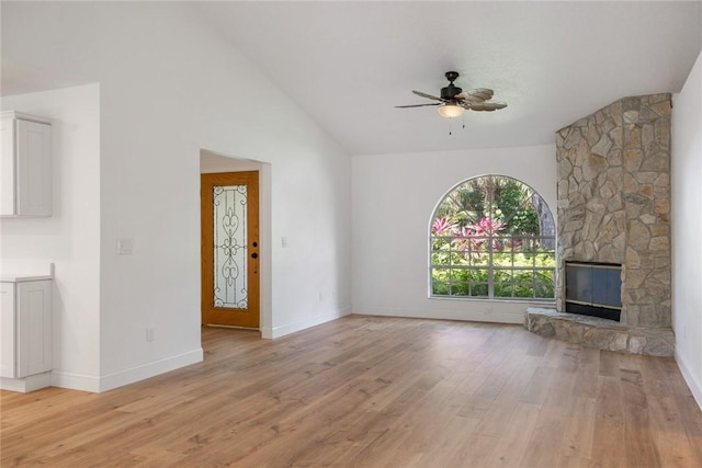 725 Wentworth St, Sebastian, FL 32958 - unfurnished living room with a ceiling fan, light wood finished floors, a stone fireplace, baseboards, and high vaulted ceiling
