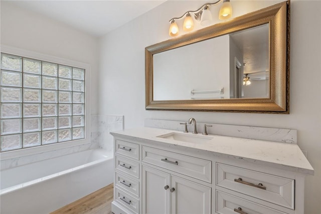 725 Wentworth St, Sebastian, FL 32958 - bathroom with vanity, a tub, wood finished floors, and a ceiling fan