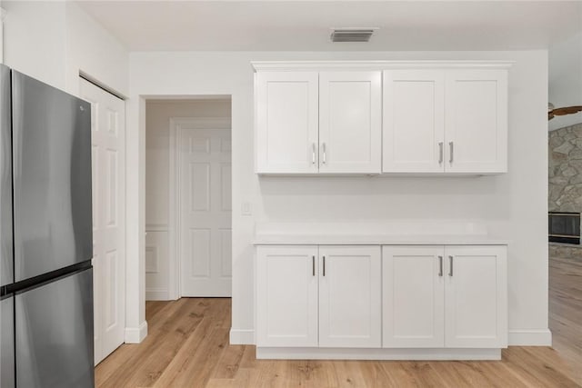 725 Wentworth St, Sebastian, FL 32958 - kitchen view of freestanding refrigerator, white cabinets, light countertops, and light wood-type flooring