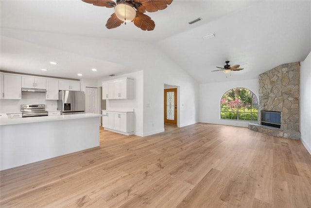 725 Wentworth St, Sebastian, FL 32958 - unfurnished living room featuring ceiling fan, vaulted ceiling, light wood-style flooring, a fireplace, and baseboards