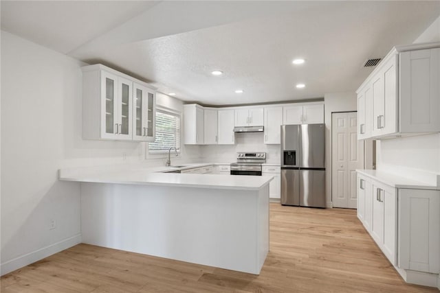 725 Wentworth St, Sebastian, FL 32958 - kitchen featuring appliances with stainless steel finishes, a sink, under cabinet range hood, a peninsula, and glass insert cabinets