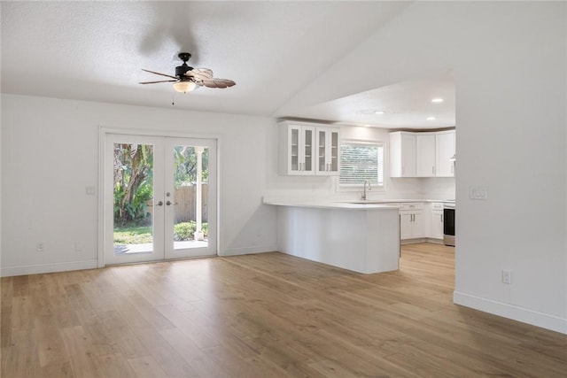 725 Wentworth St, Sebastian, FL 32958 - kitchen featuring a peninsula, a ceiling fan, white cabinets, glass insert cabinets, and light wood finished floors