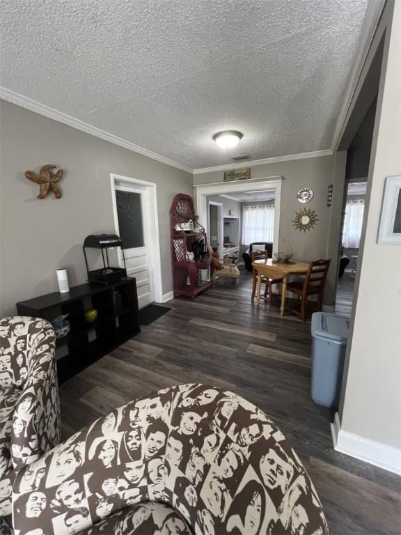 living area featuring ornamental molding, wood finished floors, a textured ceiling, and baseboards