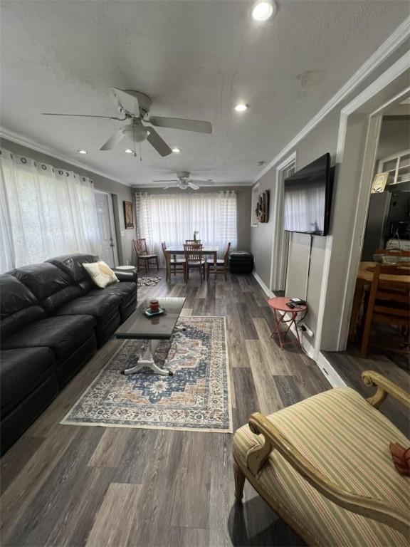 living area with ornamental molding, a ceiling fan, recessed lighting, and wood finished floors