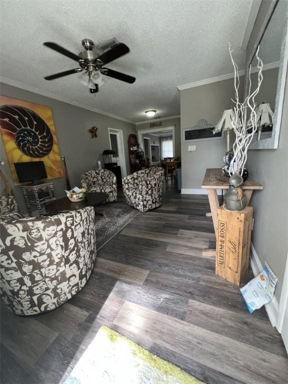 living room featuring crown molding, wood finished floors, ceiling fan, a textured ceiling, and baseboards