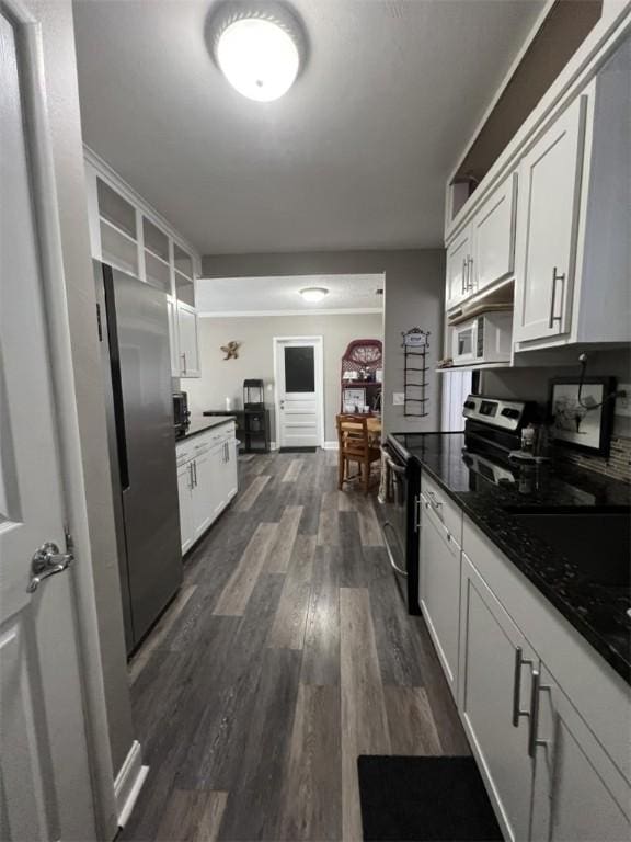 kitchen with appliances with stainless steel finishes, dark wood finished floors, and white cabinets