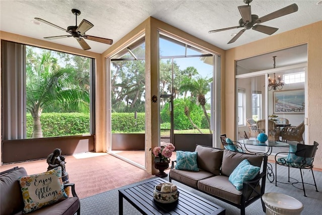 sunroom / solarium with vaulted ceiling and ceiling fan with notable chandelier