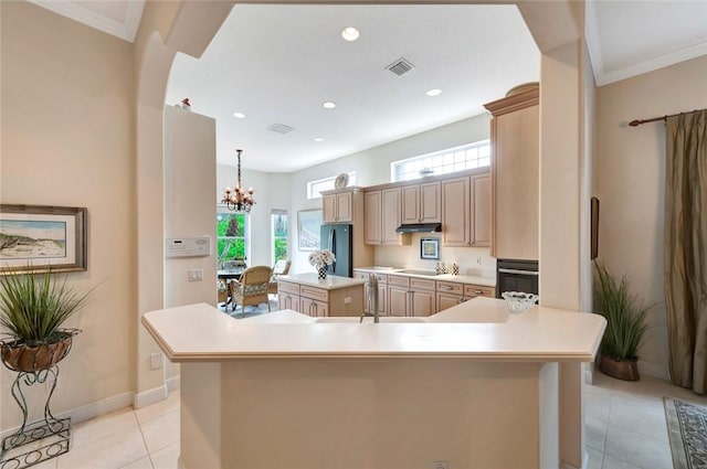 kitchen featuring stainless steel refrigerator, light brown cabinets, a notable chandelier, pendant lighting, and a spacious island