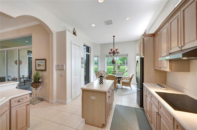 kitchen featuring an inviting chandelier, hanging light fixtures, light tile patterned floors, a kitchen island, and stainless steel refrigerator