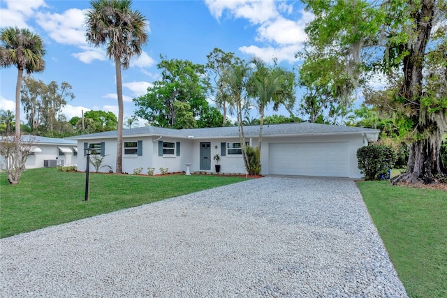 ranch-style house with an attached garage, central air condition unit, a front yard, stucco siding, and gravel driveway