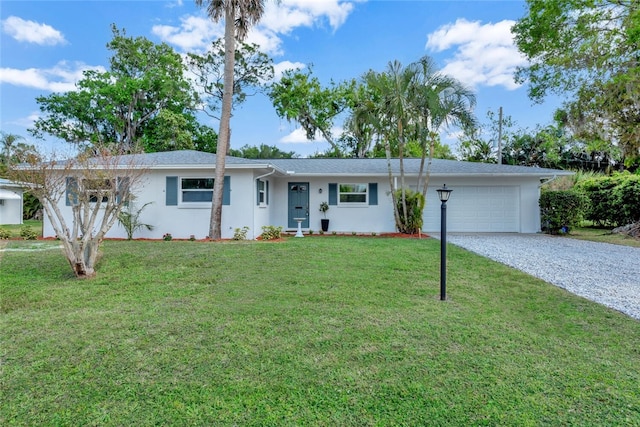 single story home featuring a garage, driveway, a front lawn, and stucco siding