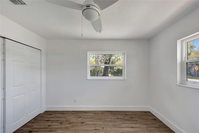 unfurnished bedroom featuring visible vents, ceiling fan, baseboards, and wood finished floors