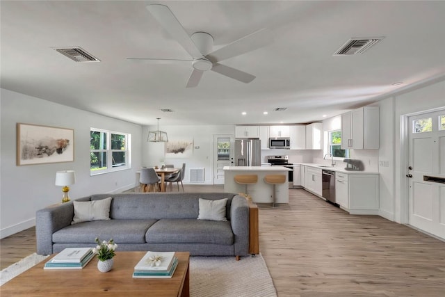 living room featuring visible vents and light wood-style flooring