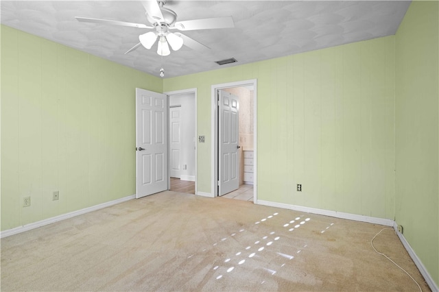 unfurnished bedroom with visible vents, a ceiling fan, connected bathroom, carpet, and baseboards