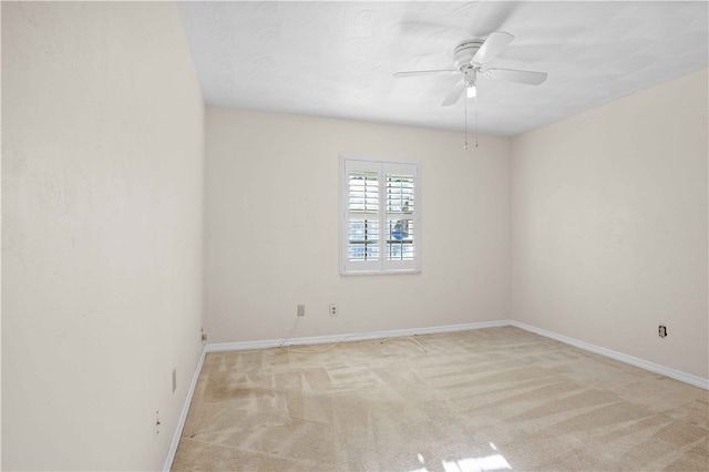 unfurnished room featuring baseboards, light colored carpet, and a ceiling fan