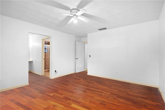 spare room with baseboards, wood finished floors, visible vents, and ceiling fan