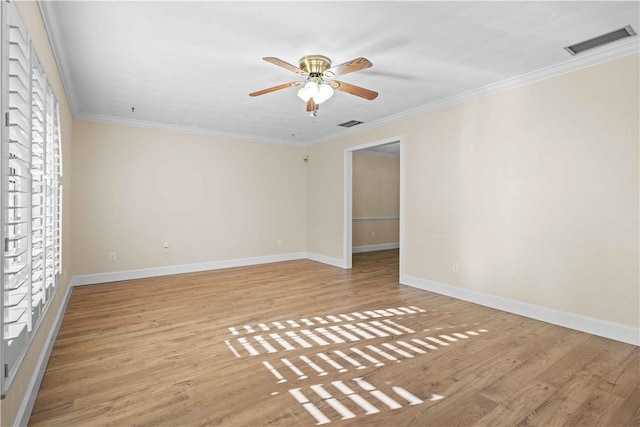 spare room featuring baseboards, visible vents, light wood-style flooring, ceiling fan, and ornamental molding