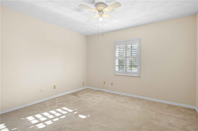 unfurnished room with a ceiling fan, light colored carpet, and baseboards