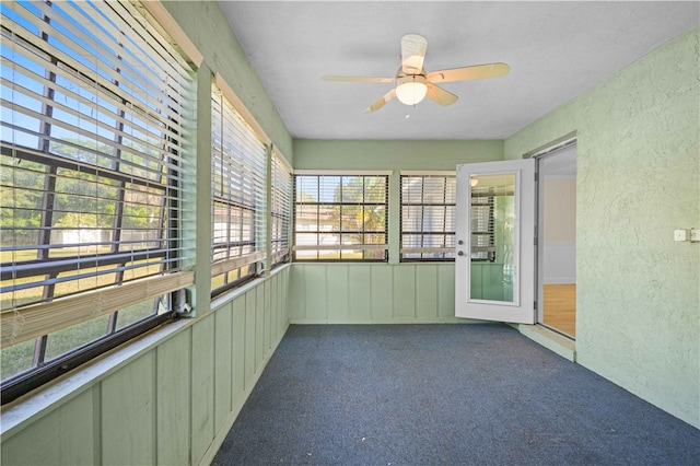 unfurnished sunroom with ceiling fan