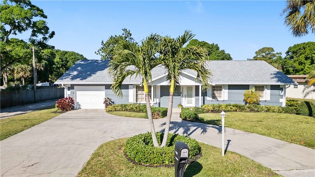 ranch-style house featuring stucco siding, a front lawn, driveway, fence, and a garage