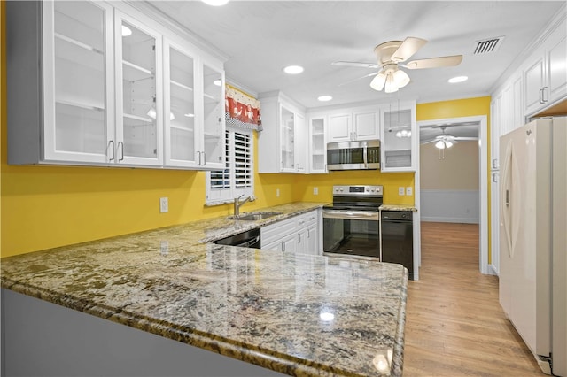 kitchen with visible vents, white cabinets, stainless steel appliances, a ceiling fan, and a sink