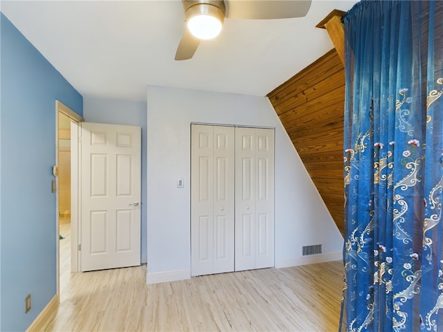 unfurnished bedroom with ceiling fan, a closet, and light wood-type flooring