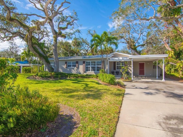 ranch-style house featuring a front lawn and a carport