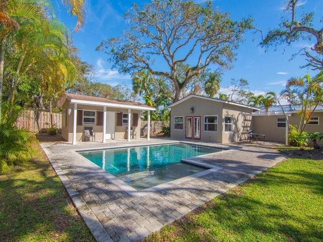 view of pool with an exterior structure, fence, an outbuilding, and a patio area