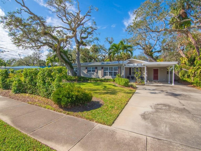 ranch-style home with a front yard and a carport